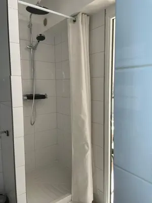 a shower with a white shower curtain in a bathroom at Studio climatisé plein centre ville 2ème ETAGE in Aix-en-Provence