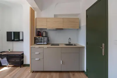 a kitchen with a sink and a green door at Studio climatisé plein centre ville 2ème ETAGE in Aix-en-Provence