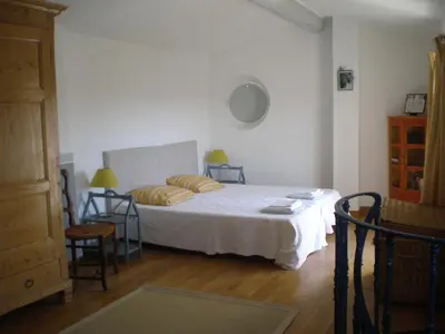 a bedroom with a bed and a table and chairs at Campanina in Bonnieux
