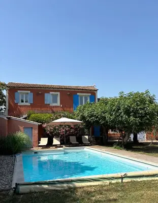 a swimming pool in front of a house at Mas de charme provencal in Cavaillon