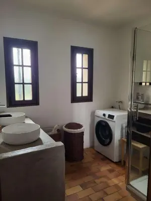 a bathroom with two sinks and a washing machine at Maison Provençale Vue Étang & Charme Médiéval in Saint-Chamas