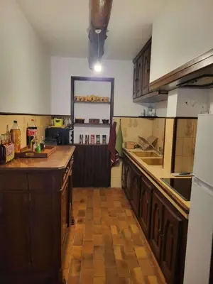 a kitchen with wooden cabinets and a counter top at Maison Provençale Vue Étang & Charme Médiéval in Saint-Chamas