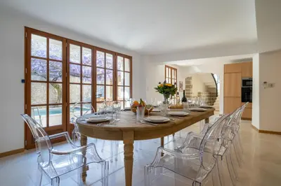 a dining room with a large wooden table and chairs at Exceptionnel - Couvent entièrement rénové - classé Patrimoine - Piscine, au calme et à 100 m du coeur de l'Isle in LʼIsle-sur-la-Sorgue