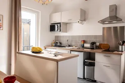 a kitchen with white cabinets and a counter top at Charmant Appartement au Cœur du Village de Bedoin in Bédoin