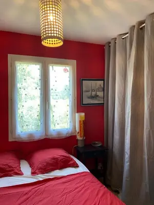 a red bedroom with a bed and two windows at Villa climatisée dans Domaine privé Aix en Provence in Aix-en-Provence