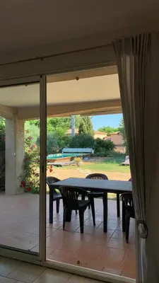 a table and chairs on a patio with a glass door at Villa climatisée dans Domaine privé Aix en Provence in Aix-en-Provence