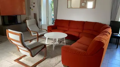 a living room with a red couch and two chairs at Villa climatisée dans Domaine privé Aix en Provence in Aix-en-Provence
