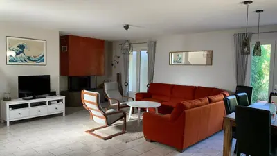 a living room with a red couch and a tv at Villa climatisée dans Domaine privé Aix en Provence in Aix-en-Provence