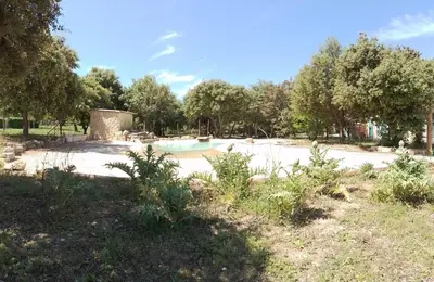 a swimming pool in a park with trees at Lou mazet in La Roque-sur-Pernes