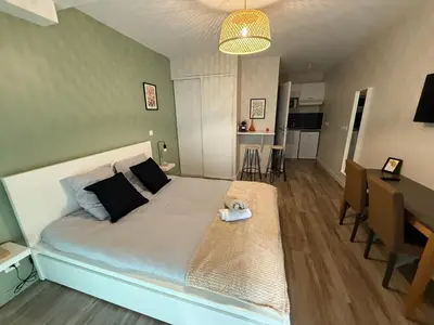 a bedroom with a large bed and a dining room at 119 Sous le ciel de Provence - Aix in Éguilles