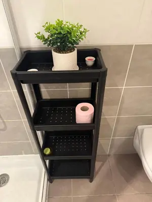 a black end table in a bathroom with a plant at 119 Sous le ciel de Provence - Aix in Éguilles