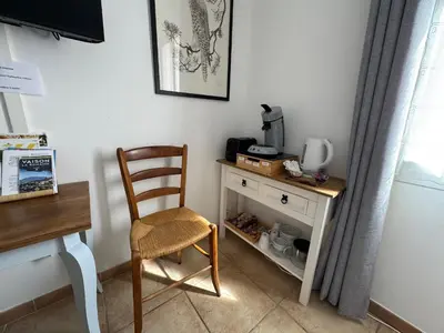 a desk with a chair and a table with a coffee maker at Chez DOMI in LʼIsle-sur-la-Sorgue