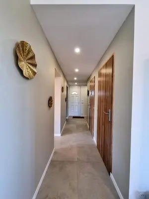 a hallway with white walls and a door with a gold bow at Lou Miradou in Maubec