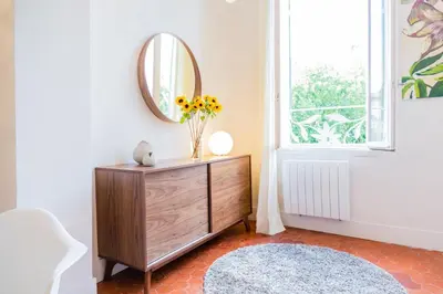 a vase of flowers on a dresser in a room with a mirror at Gorgeous! heart of Aix en Provence appartement climatisé in Aix-en-Provence