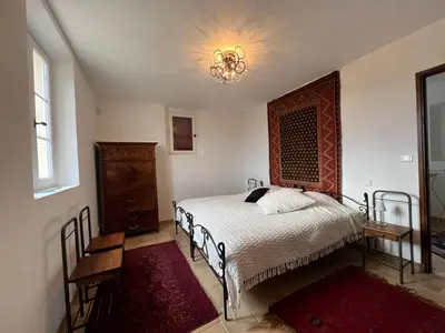 a bedroom with a bed and a chandelier at Le Mas de Quatremonts - Your refuge in Provence in Bonnieux