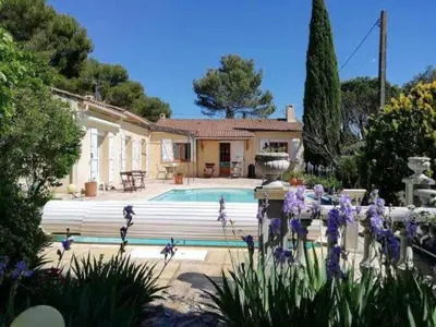 a house with a swimming pool and flowers in front of it at Maison provençale familiale avec piscine - 6 personnes in Lambesc