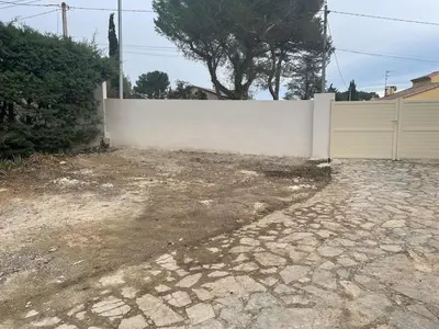 a driveway in front of a white fence at Maison provençale familiale avec piscine - 6 personnes in Lambesc