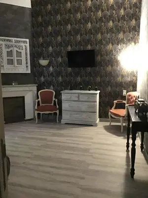 a living room with a tv and a dresser and chairs at Gites victoria in Cavaillon