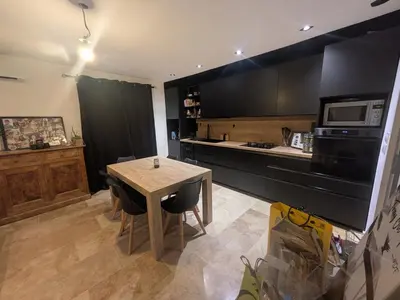 a kitchen with a table with chairs and a microwave at charmante petite maison - piscine hors sol - proche Avignon in Avignon