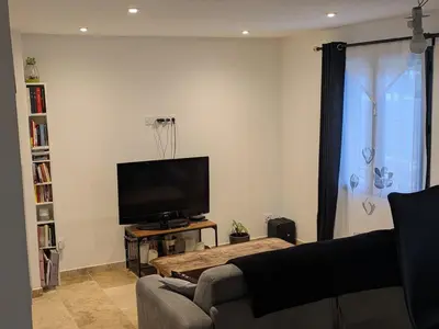 a living room with a couch and a flat screen tv at charmante petite maison - piscine hors sol - proche Avignon in Avignon