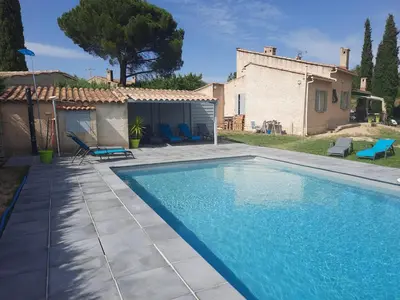 a swimming pool in front of a house at Villa avec piscine dans le Luberon in La Tour-dʼAigues