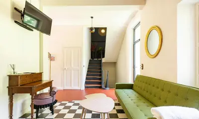 a living room with a green couch and a piano at House By The Sorgue River With Private Access in Fontaine-de-Vaucluse