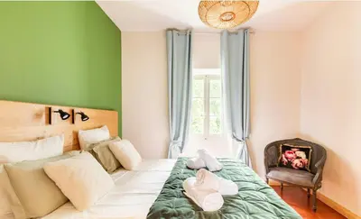 a bedroom with green walls and a bed with a chair at House By The Sorgue River With Private Access in Fontaine-de-Vaucluse