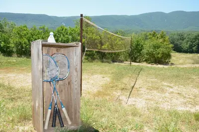 a net with two tennis rackets in a field at Bright Villa In The Heart Of Luberon in Céreste