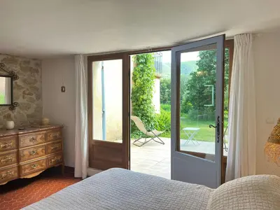 a bedroom with a bed and a bathroom with a tub at Historic Bastide With Private Pool In The Luberon in Céreste