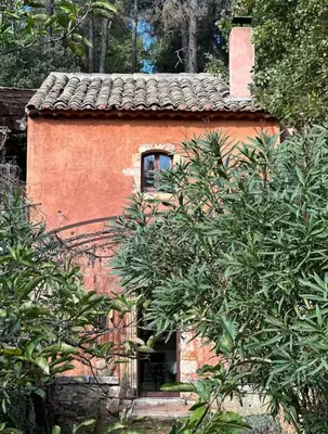 a small orange house with a window and trees at Bohemian House Overlooking Roussillon in Roussillon