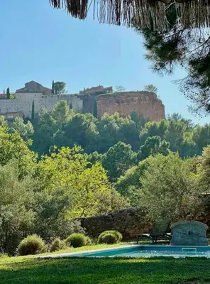 a pool with a view of a castle in the background at Bohemian House Overlooking Roussillon in Roussillon