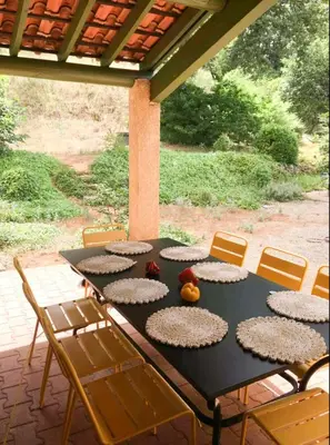 a black table with chairs and fruit on a patio at Peaceful Retreat In The Heart Of Luberon in Roussillon
