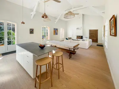 a kitchen and living room with a table and stools at Grande maison de famille rénovée, vue sur Sainte Victoire in Venelles