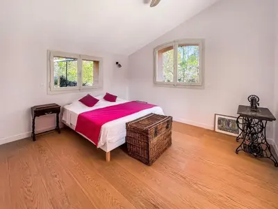 a bedroom with a large bed and two windows at Grande maison de famille rénovée, vue sur Sainte Victoire in Venelles