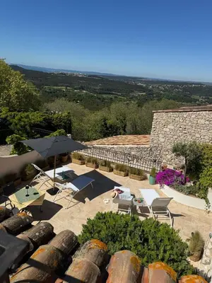 a view of a patio with an umbrella and chairs at Les Terrasses de Ventabren in Ventabren
