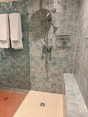 a bathroom with a shower with a tiled floor at Les Terrasses de Ventabren in Ventabren