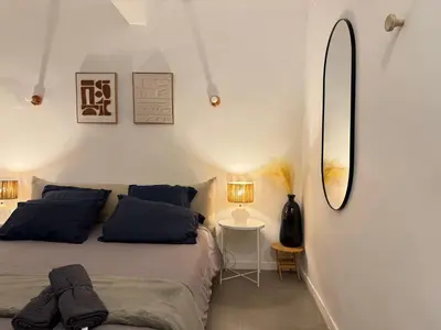 a bedroom with a bed and a mirror and a table at Chic et Cosy, Hyper centre in Aix-en-Provence