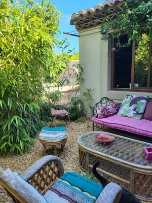 a patio with a couch and a table and chairs at le cabanon du clos in LʼIsle-sur-la-Sorgue