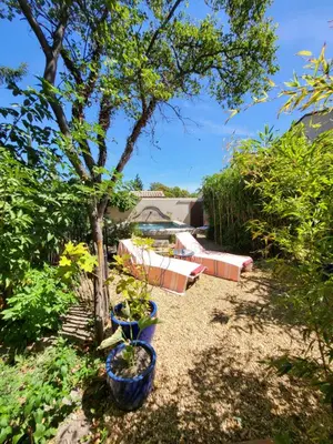 a garden with two blue pots and a tree at le cabanon du clos in LʼIsle-sur-la-Sorgue