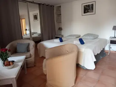 a hotel room with two beds and two chairs at Gîte Lavande vue Luberon 33 hectares piscine Spa Sauna au cœur de Provence in Saumane-de-Vaucluse