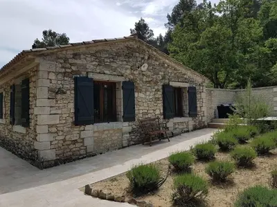 a stone house with a bench in front of it at Air-conditioned Stylish Provence Villa in Oppède