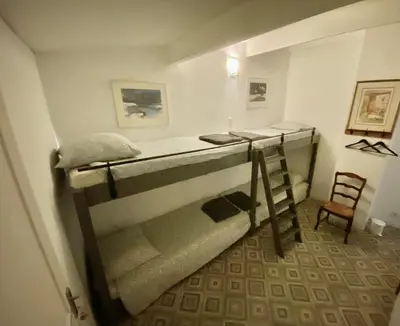 two bunk beds in a room with a chair at La Roselière in Mérindol