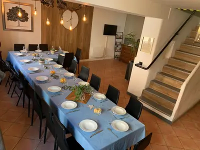 a long table in a room with blue tables and chairs at La Roselière in Mérindol