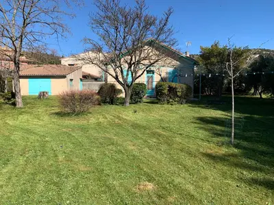 a house with a yard with a tree in front of it at La Roselière in Mérindol