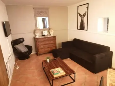 a living room with a black couch and a table at La Roselière in Mérindol