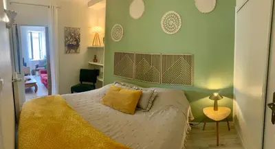 a bedroom with a bed with a yellow comforter at Appartement cosy lumineux et calme in Apt