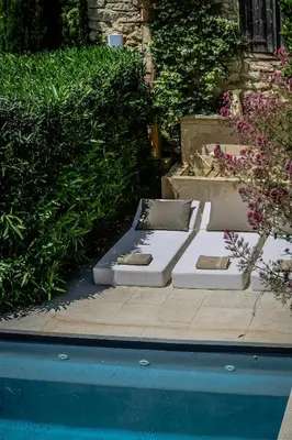 two beds sitting next to a swimming pool at Character House In The Heart Of Gordes in Gordes
