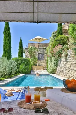 a villa with a swimming pool with a table with drinks at Character House In The Heart Of Gordes in Gordes