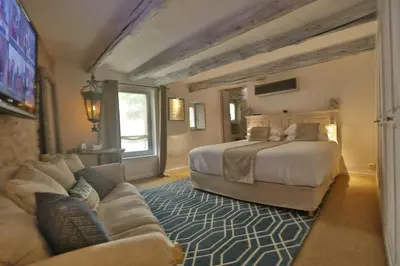 a large bedroom with a bed and a couch at Character House In The Heart Of Gordes in Gordes