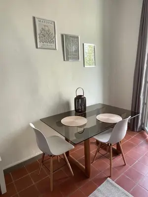 a dining room table with two chairs and a tea kettle on it at Studio avec balcon sur cour in Aix-en-Provence